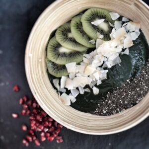 This spirulina smoothie bowl recipe is made with frozen banana and kiwis, topped with chia seeds and coconut flakes.