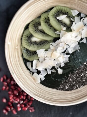 This spirulina smoothie bowl recipe is made with frozen banana and kiwis, topped with chia seeds and coconut flakes.